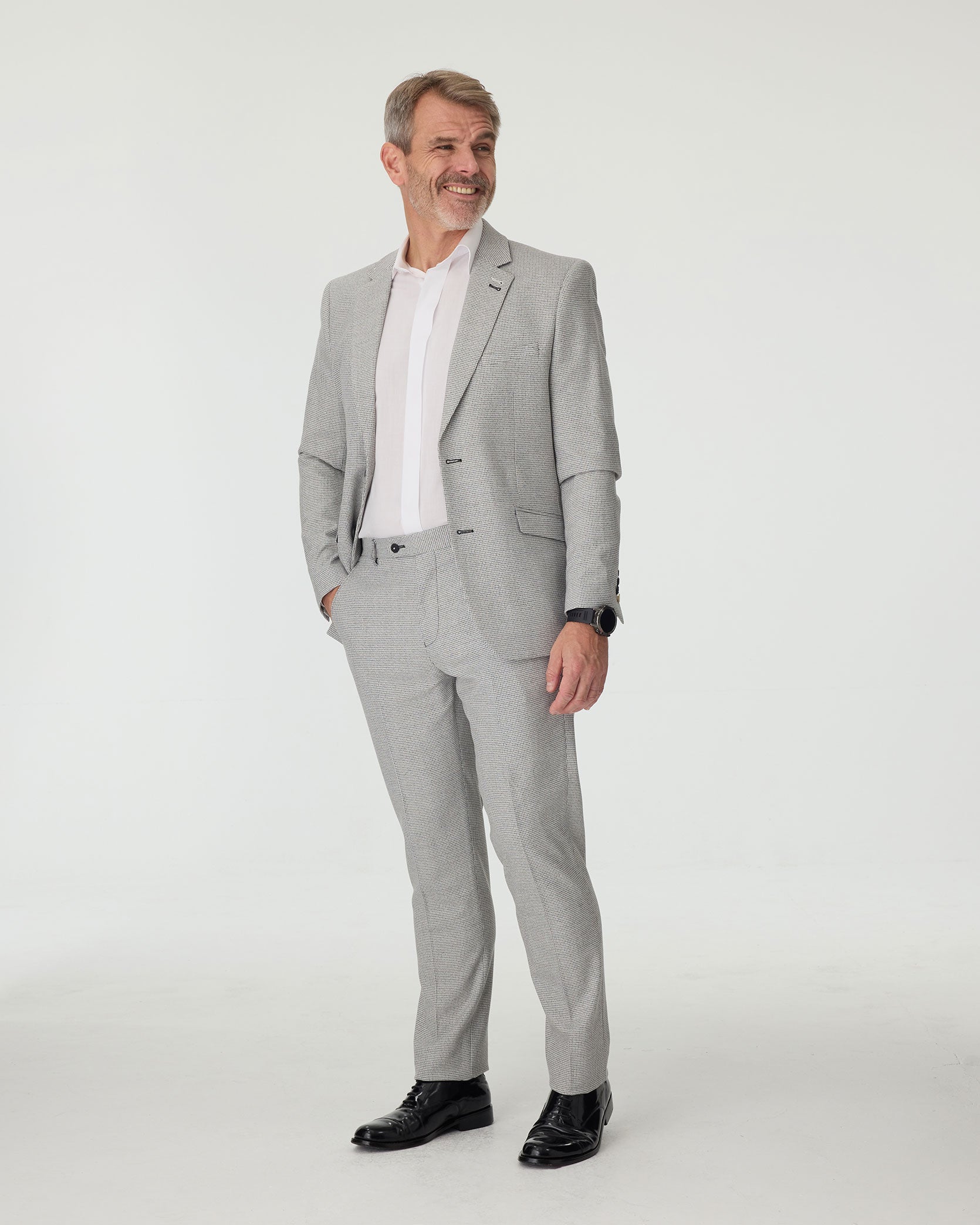 Man wearing a gray checkered suit with a white shirt on a white background