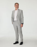 Man wearing a gray checkered suit with a white shirt on a white background