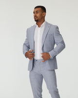 Man wearing a sky blue checkered suit with a white shirt on a plain background